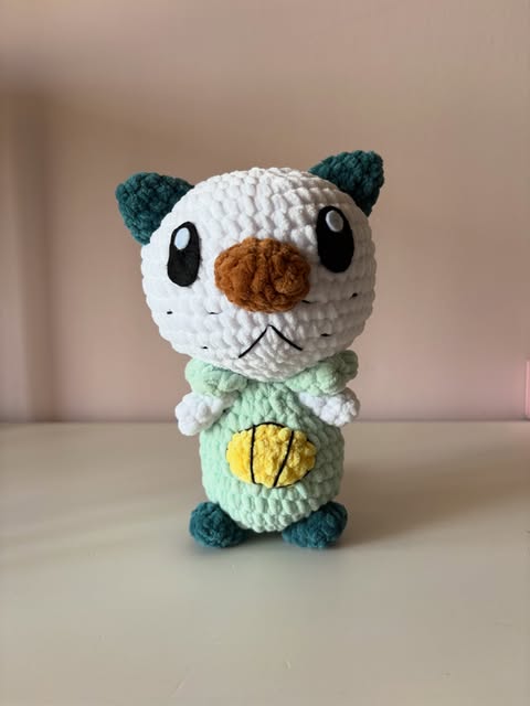 Peluche Oshawott con testa bianca, orecchie verde petrolio e corpo verde chiaro